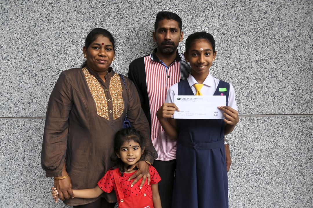 就读淡米尔小学六年级的米莎达妮（右一）领取慈济颁发的现值卡后，与父母及妹妹欢喜地合照留影。 【摄影：王秀玉】