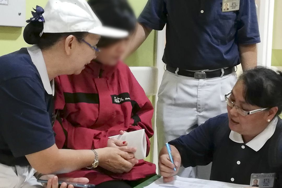 志工在烧伤护理病房外关怀伤患家属，并献上祝福金。 【摄影：蔡秉俊】