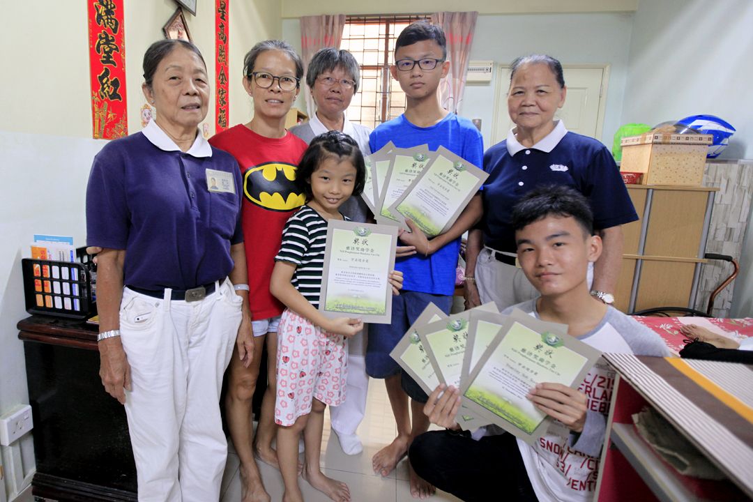 Thanks to care and guidance from the volunteers and supervision from their mother (in red), the children are motivated to strive for improvements. [Photograph by Julie Yen Yu Chu]