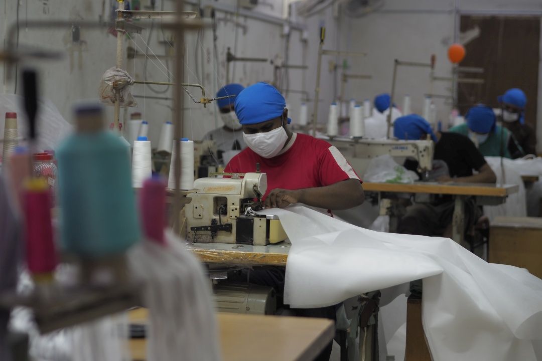 慈济雪隆分会牵起爱的生产线，动员多家制衣厂赶制医用隔离衣及防护靴套，以提供给雪隆各源流医院前线医护人员使用。 【摄影：覃平福】