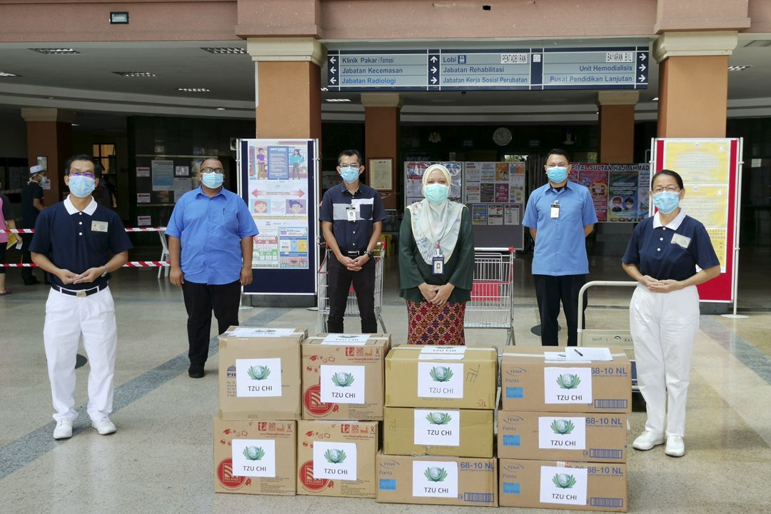 志工张锦华（左）与李金勤把与医疗面罩送到淡马鲁医院，并由副院长诺依达雅（PUAN NUOHIDAYAH) 亲自签收领取。 【摄影：罗添发】