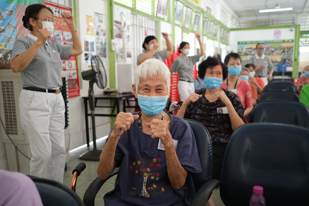 暌违三十三个月,志工与银禧老妇院的阿嬷们等来了欢喜重聚的这刻；阿嬷们跟随志工做团康，不由喜上眉梢。【摄影：林振胜】