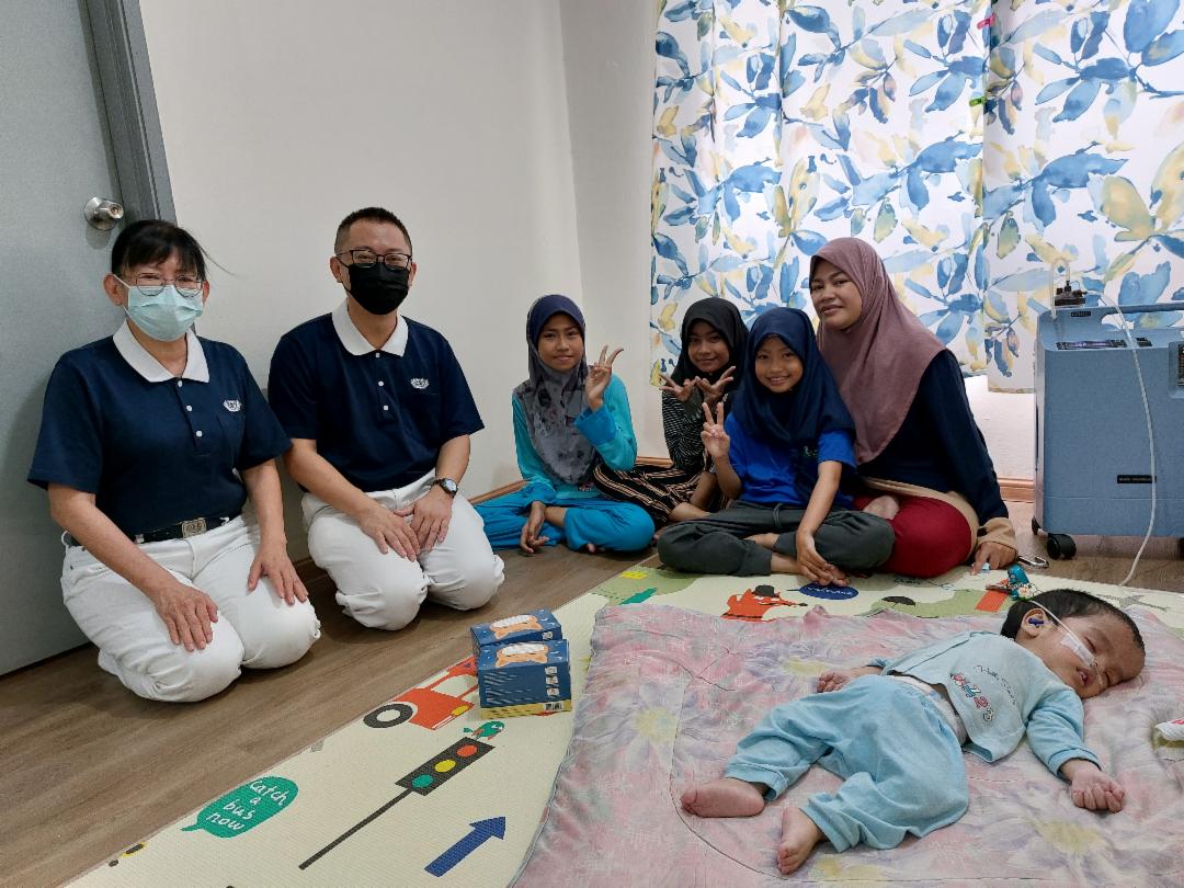 Juliza’s youngest child suffered from macrocephaly, hydrocephalus, and severe hearing loss in one ear. He also could not focus his eyes and needed constant oxygen supply, and ankle support to prevent deformities as he grew older, as well as nasal feeding to avoid choking. [Photo by Teng Pick Cheang]