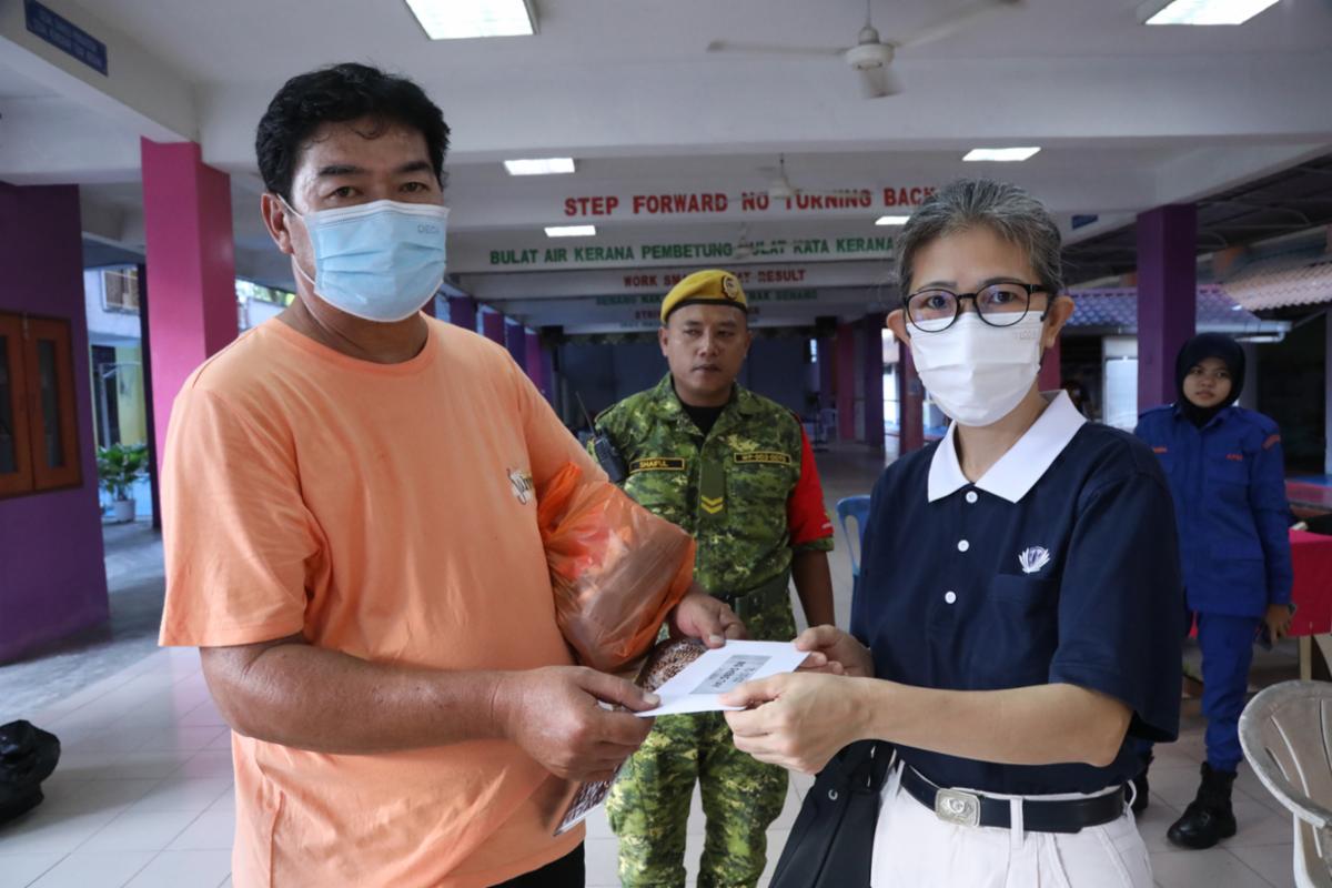 志工许丽珠（右）获悉住家附近的沙巴人民组屋发生火灾，一连三天到现场关怀，并在14日发放慰问金给受灾户。 【摄影：何永康】