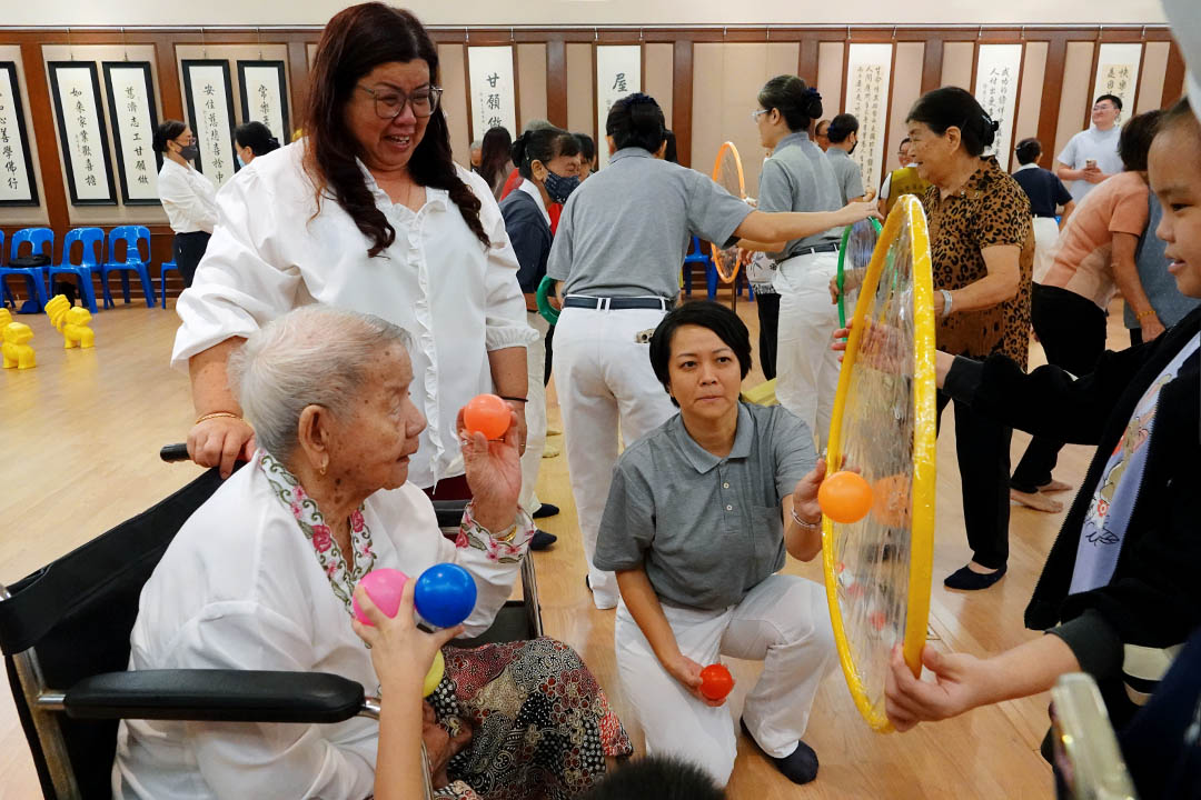 九十岁长者（左）不放弃与人群接触的机会，游戏同时，也是活络身体的好机会。【摄影：邓遂嵘】