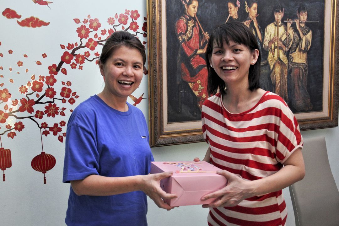志工陈秋燕（左）义卖亲手制作的蛋糕，获得社区热烈护持，目前已卖出超过一百个蛋糕。 【摄影：李贵业】