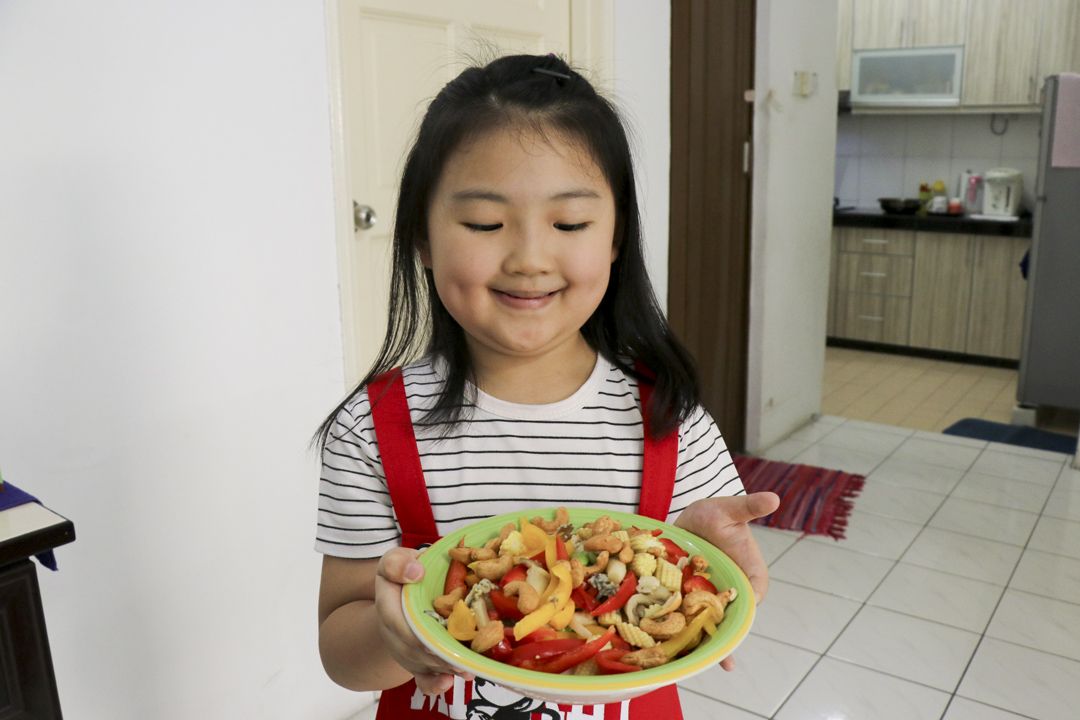 陈巧甯捧着自己有份烹煮、香喷喷的菇类，不由打从心里认同，素食其实也很好吃。 【摄影：杨文辉】