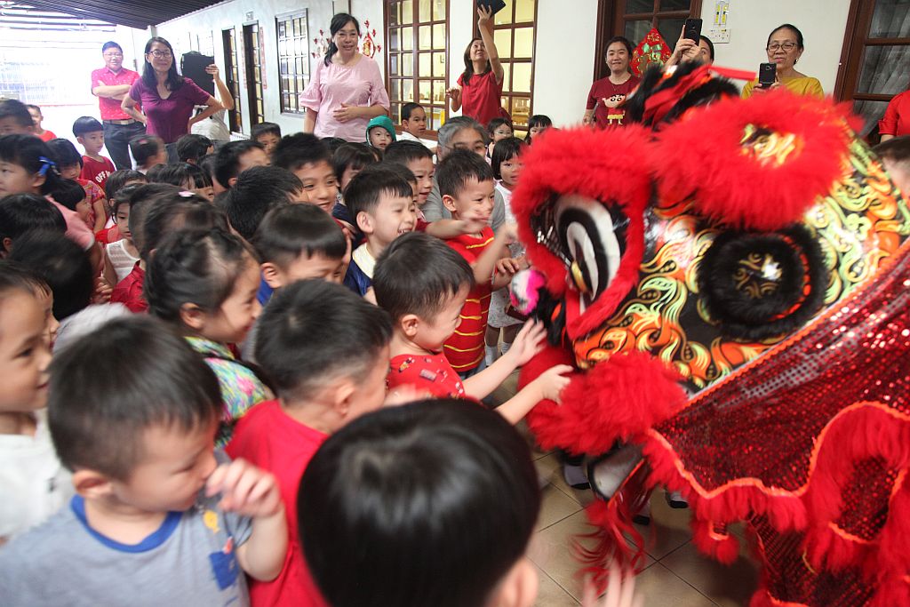  小朋友们开心涌向前去触摸舞狮。 【摄影：黄玉花】