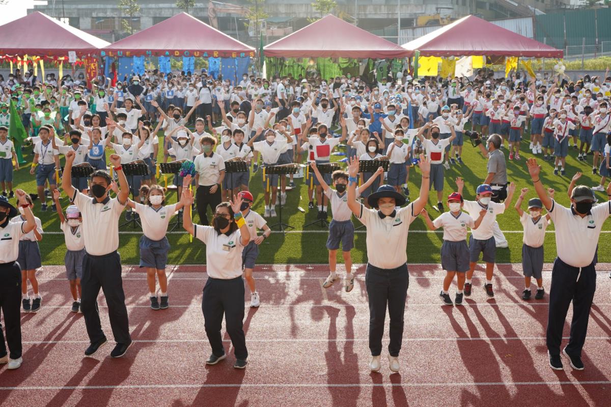 Teacher and students warming up at the opening ceremony of the 2022 primary school sports game. [Photo by Ng Shie Yuh]