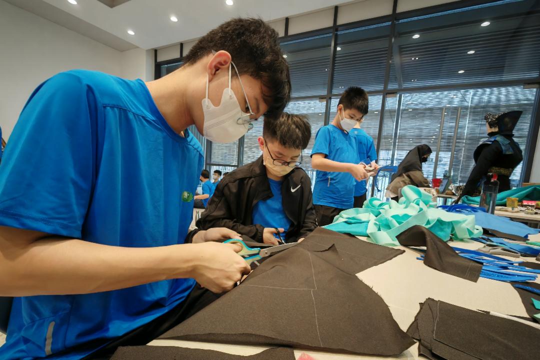 在运动周里，学生们紧锣密鼓地展开筹备运动会的工作。图为蓝组动手裁剪与制作组队的造型。 【摄影：刘玉丽】