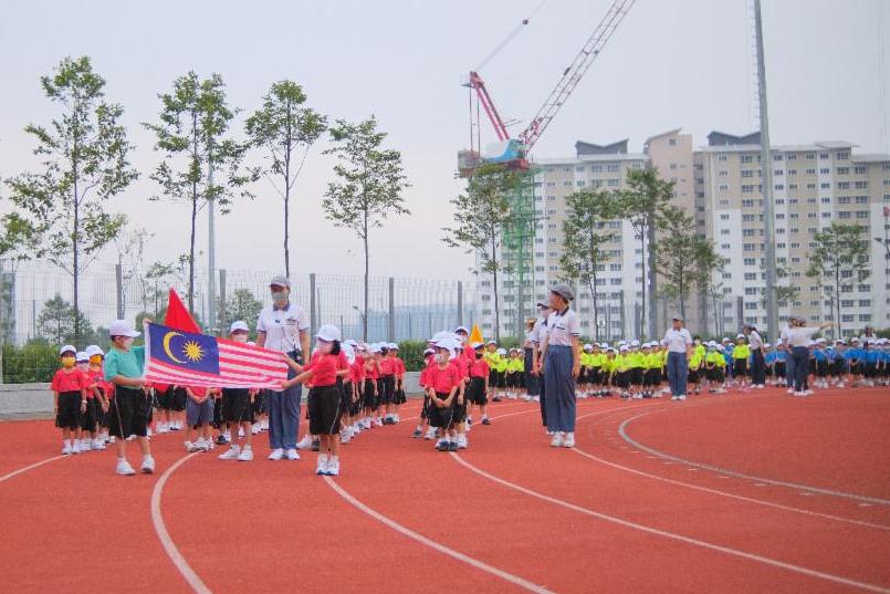  晨曦中，两位幼教孩子手执国旗，在老师陪伴下，引领红、黄、蓝、青四组队伍入场，亦为此次亲子运动会掀开序幕。 【摄影：苏永佳】