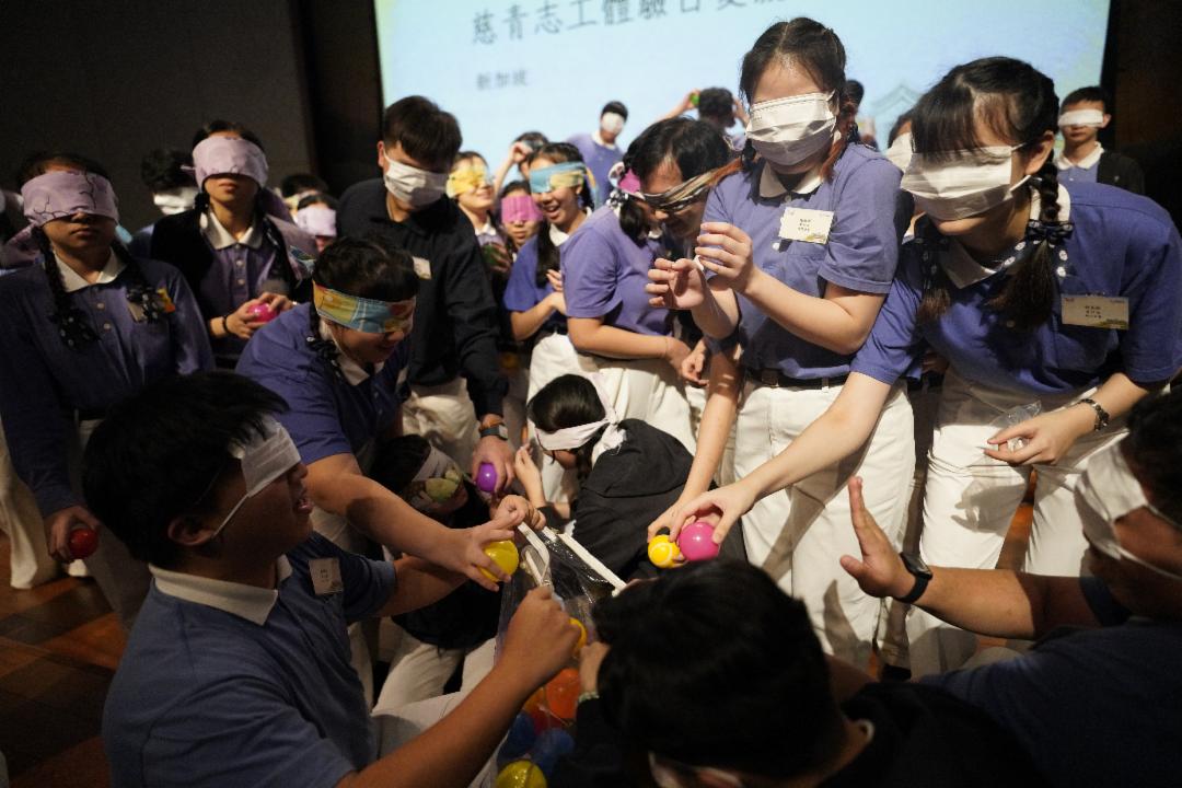 学员矇上双眼、原地转圈后，紧握着球摸索前进。看不见方向的当下，除了需要勇气，更要相信伙伴，靠着团队一起找到方向。 【摄影：黄勇雄】