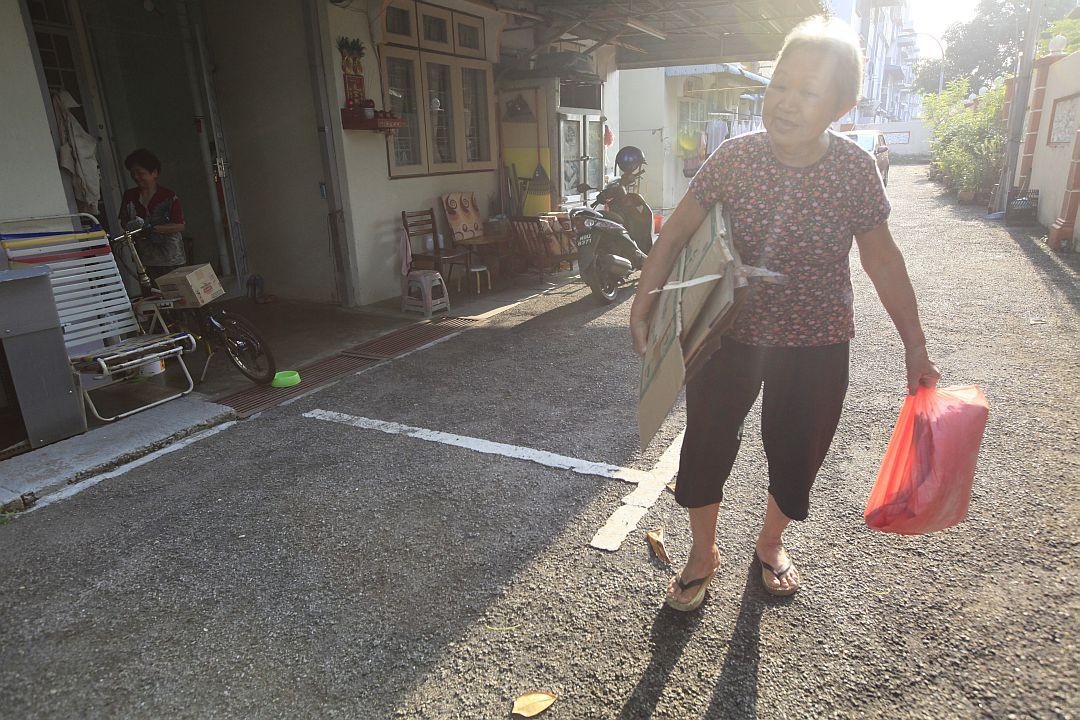 Lee Yet May eagerly collects recyclables along her designated route, unfazed by the scorching sun and her limited mobility. [Photograph by Julie Yen Yu Chu]