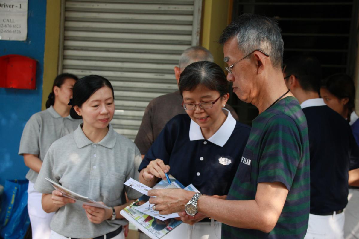 Chong Chin Wei (middle) and her team went out on the streets to share with people about Tzu Chi, evoke their compassion and guide them to contribute to charitable causes. [Photo by Teh Poh Tat]