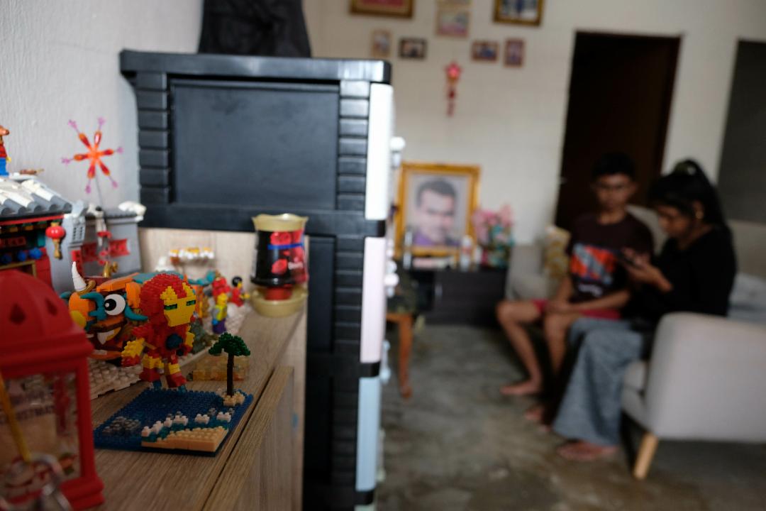 玄关旁的木制鞋架上，摆放着几件小巧的摆设：一座温馨的中式大家庭模型屋、几个木制积木玩偶，仿佛诉说着屋主对“完整家庭”的向往。【摄影：陈德铭】