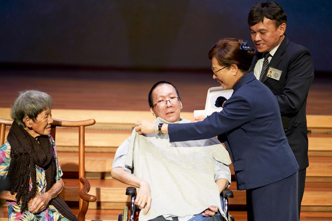 慈济雪隆分会执行长简慈露颁发灰色志工服给梁德鸿，圆满他当慈济志工的心愿。 【摄影：文伟光】