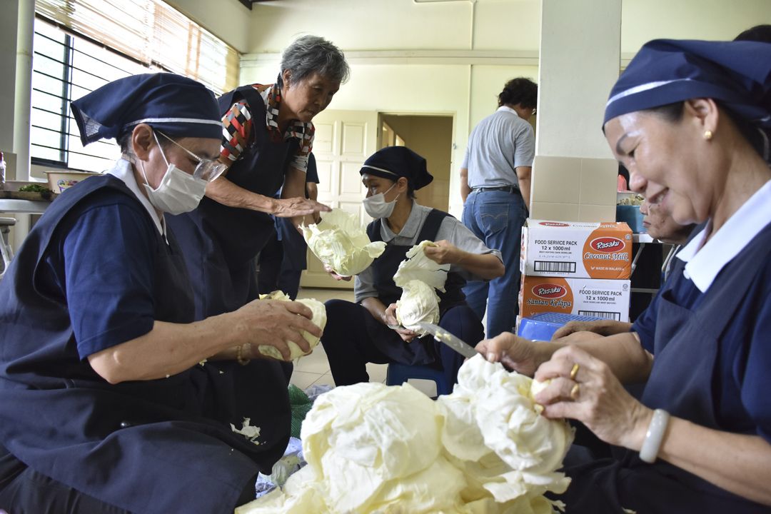 余月桃（左一）欢喜地与香积志工一同准备食材。 【摄影：符爱萍】