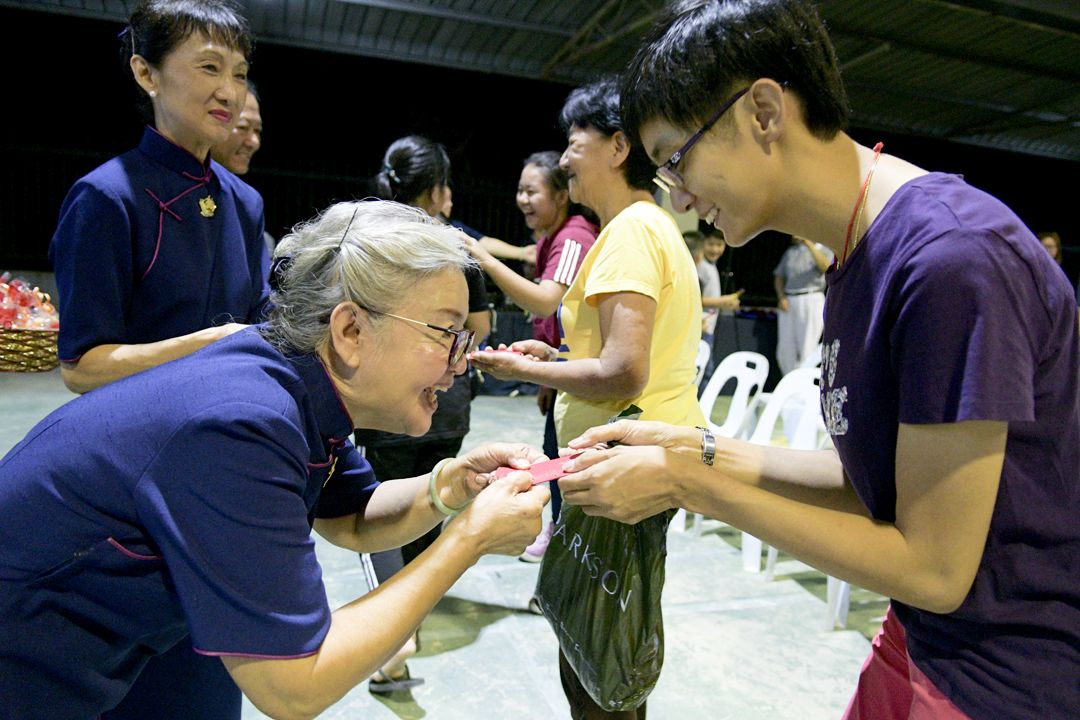 会众们开心领受‘福慧红包’的祝福。 【摄影：陈佩莉】