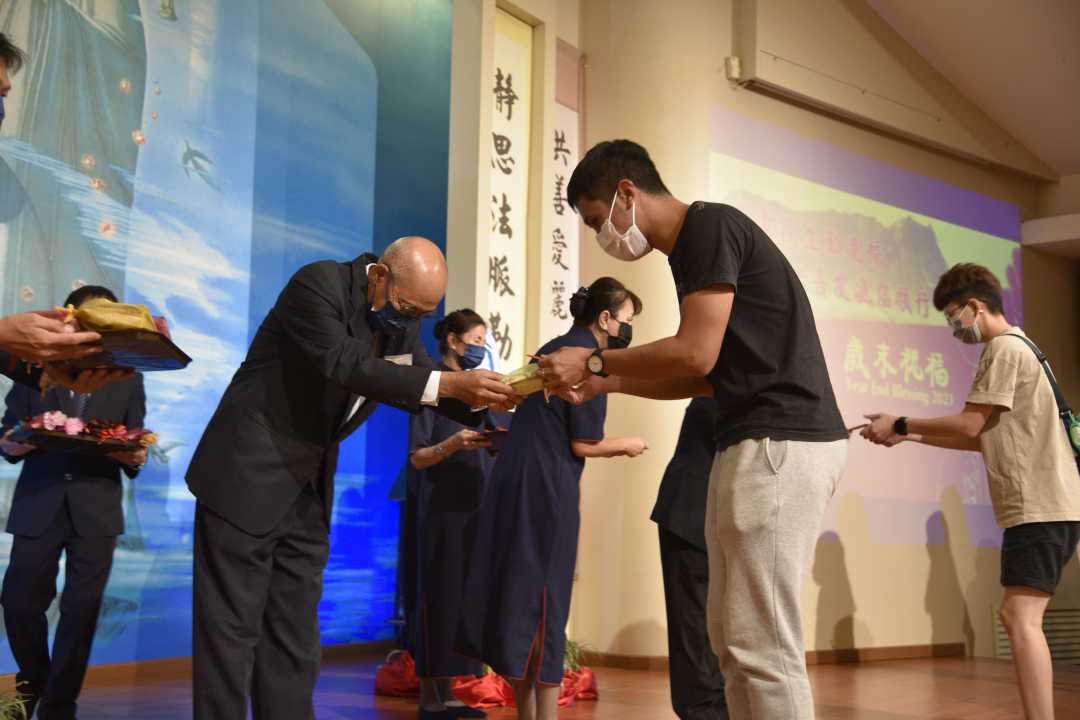 慈济亚庇副负责人翁敦学（左）恭敬地把福慧袋递给会众。【摄影：蔡德兴】