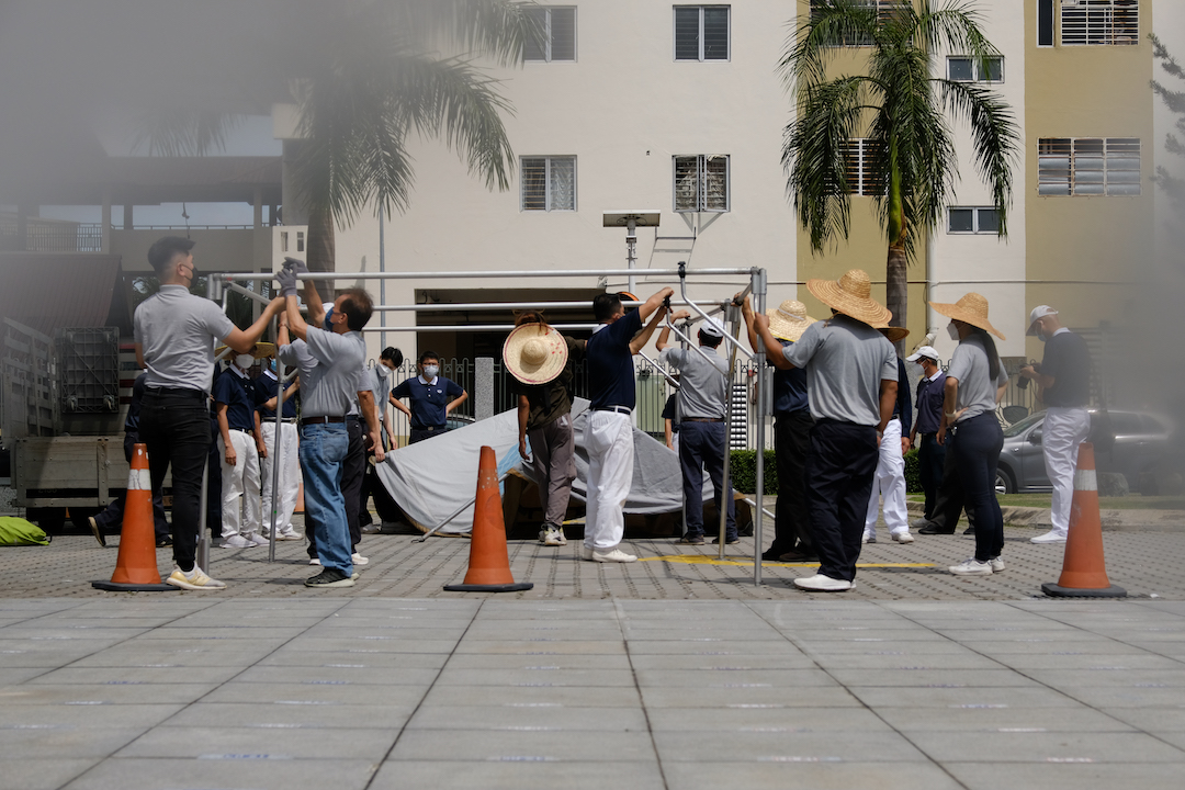 烈日下，搭起帐篷，工作团队启动了当天架设浴佛台的组装工作。【摄影：李国强】