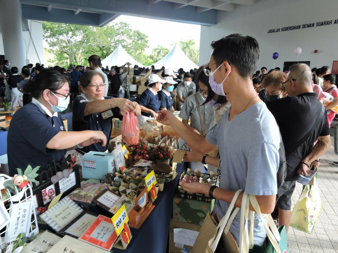 义卖会现场人潮涌动，热闹异常，精致的摆设艺品让人驻足。 【摄影者：严慧冰】