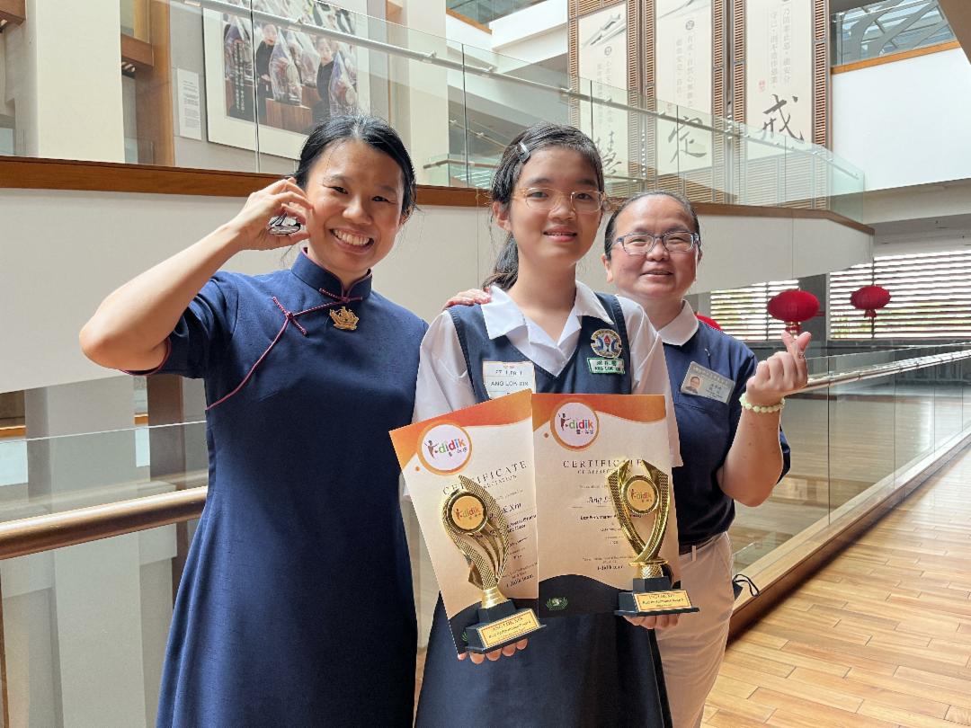 Ang Lok Xin (centre) transformed from a quiet and reserved child to a confident voice after joining the “i·didik” online tutoring programme. [Photo courtesy of community volunteers]
