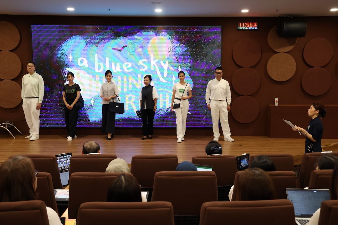 实业组志工们展示大爱感恩科技服饰系列，向企业员工说明PET宝特瓶回收再制为永续产品的过程与应用。【摄影：邓国荣】